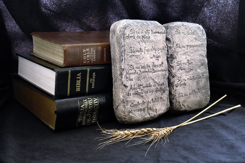 The Ten Commandments with bibles on a black background