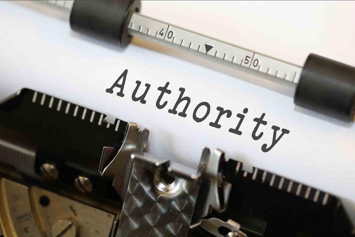 The word "Authority" being typed on paper in old fashioned typewriter