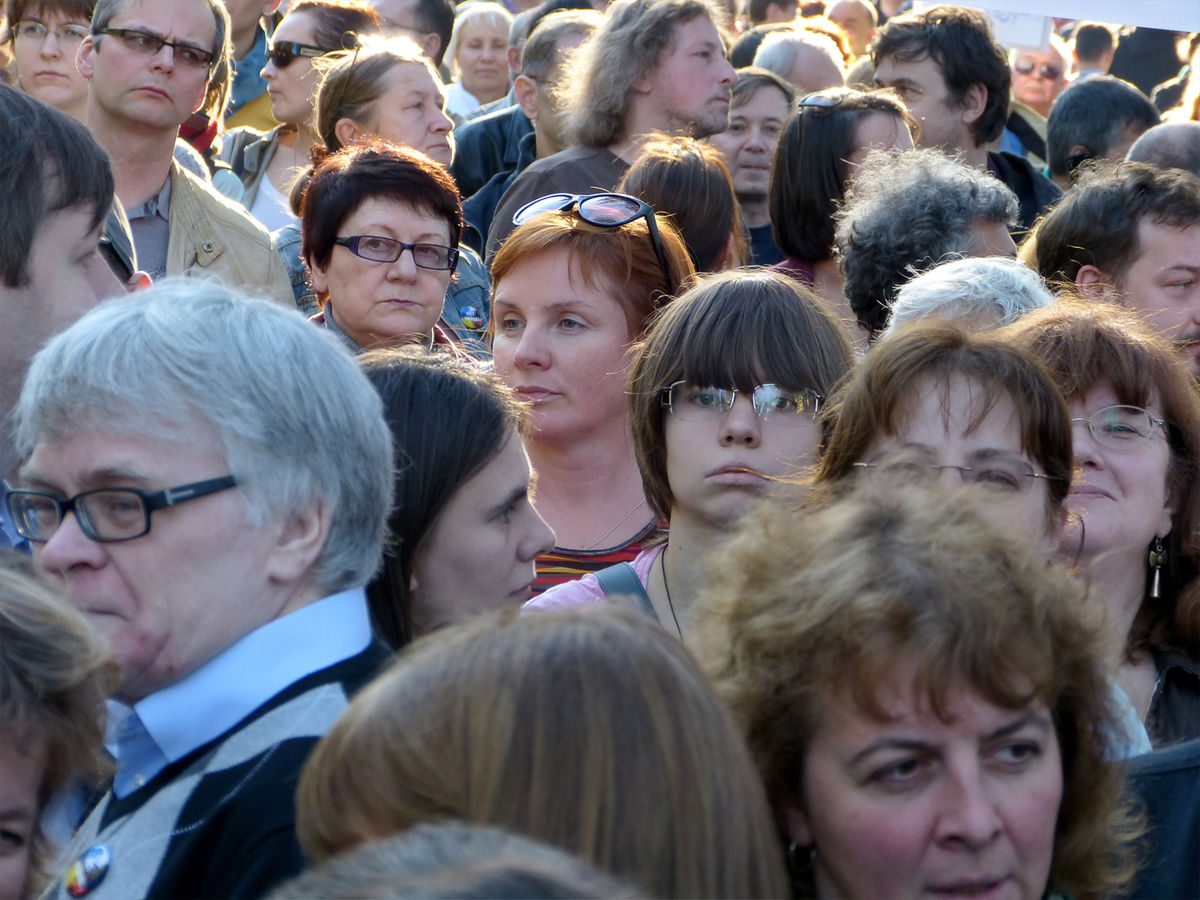 photo of crowd of people moving in the same direction