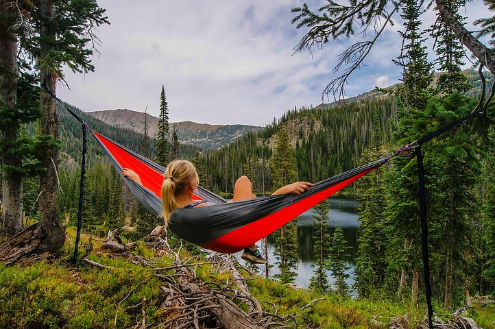 person relaxing in a hammock overlooking mountain scene