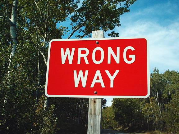 red road sign that says "WRONG WAY"