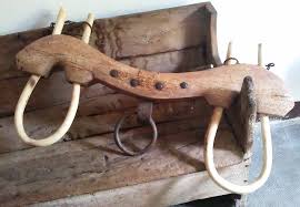 wooden yoke that looks antique sitting on an old wooden bench