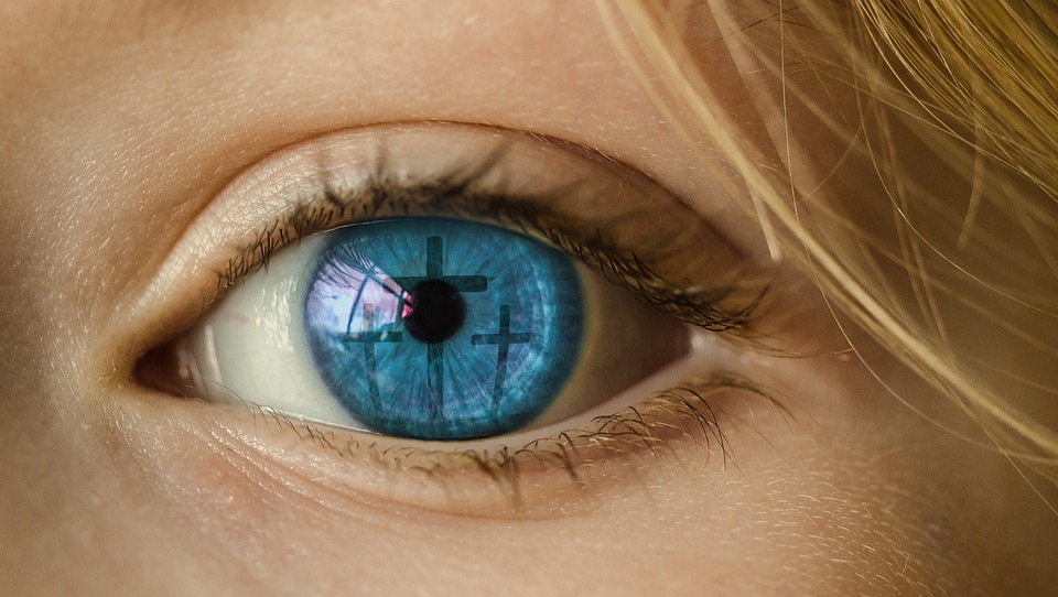 Big blue eye with reflection of the 3 crosses reflected inside