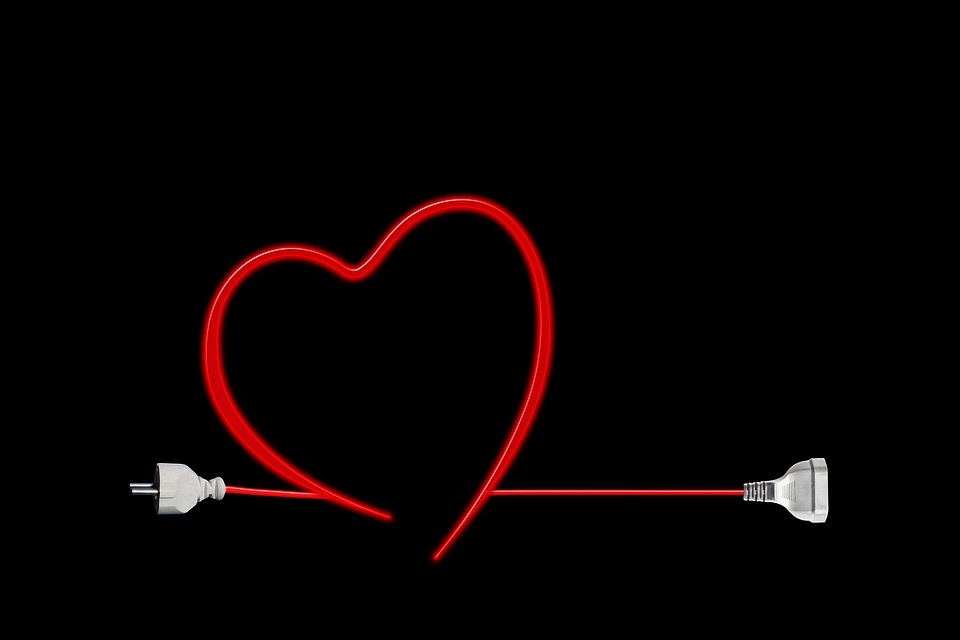 red heart with an arrow through it against black background