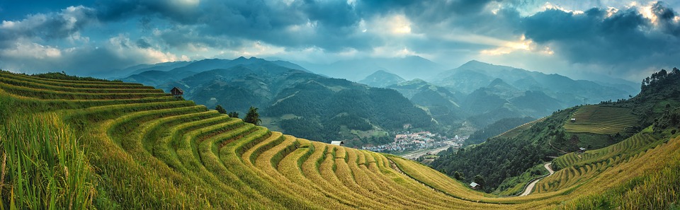 fertile farmland with mountains and city in the background