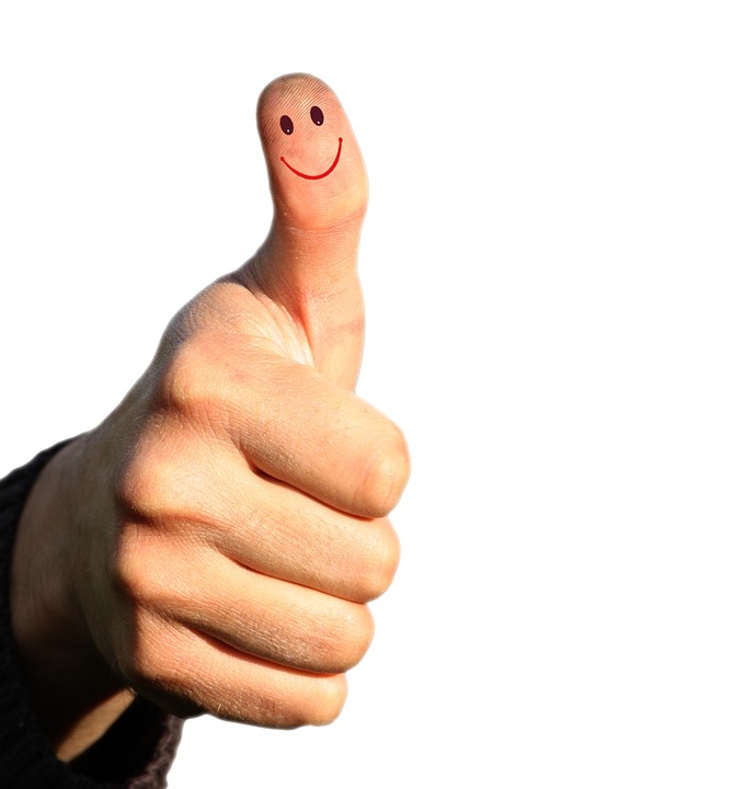 thumbs up with a smiley face on the thumb