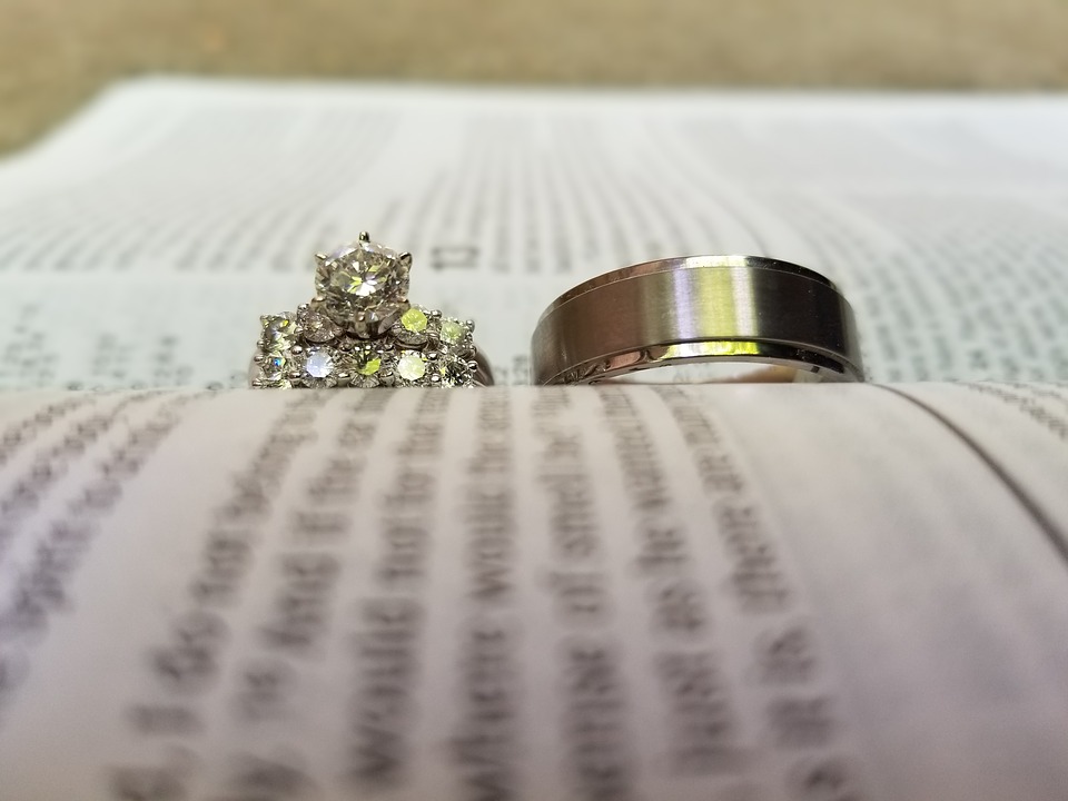 two wedding rings in sitting on an open page with words blurred out 