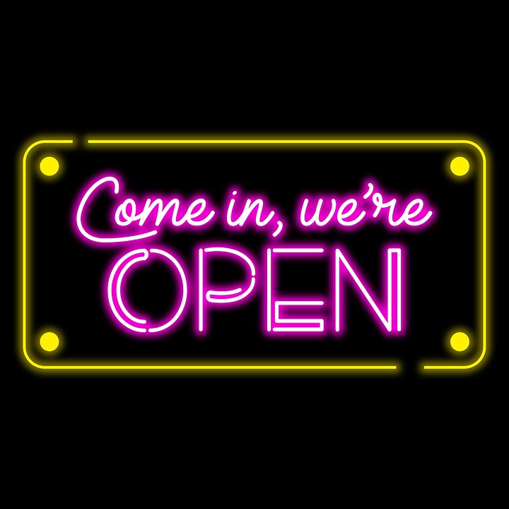 Neon sign that says, "Come in, we're OPEN"