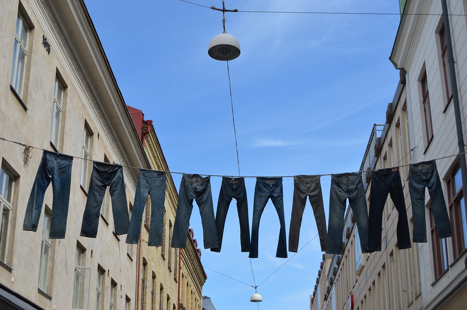 jeans hanging on a clothes line extended between buildings