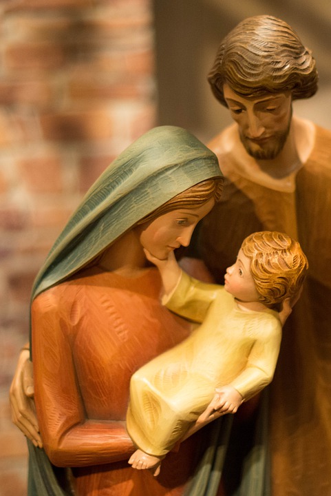 figurines of Joseph, Mary and baby Jesus with Joseph looking on with love