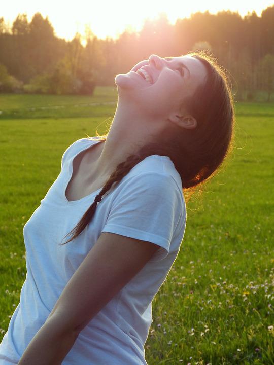 girl giving thanks and looking up to the sky with joy