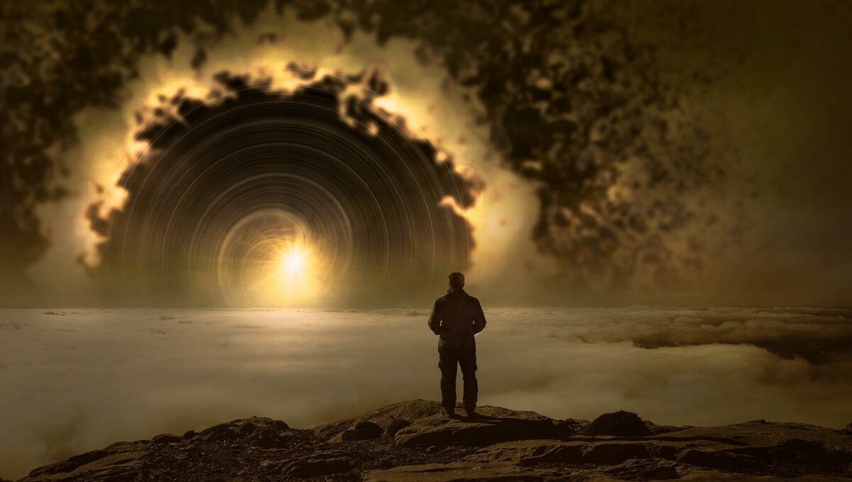 man standing on shore looking into oncoming lights with ring of light around them