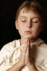 little boy praying with eyes closed