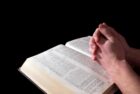 meditate on the Bible, praying hands over open Bible